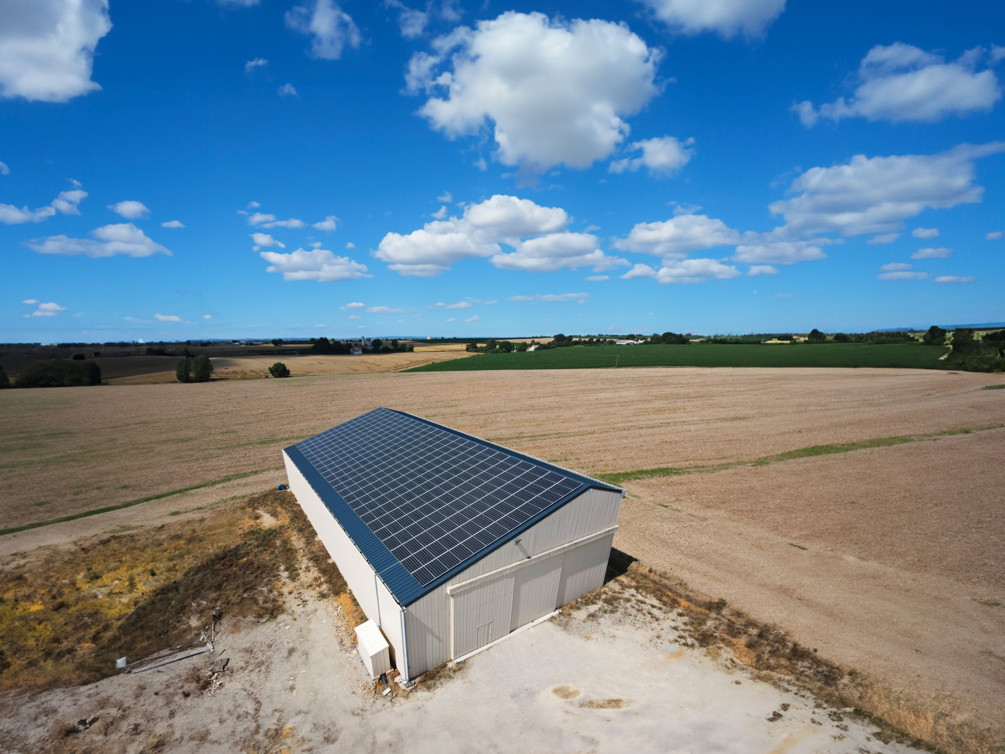 Bâtiment agricole équipé d'une solution solaire par Triangle Énergie, montrant une exploitation agricole moderne et durable.